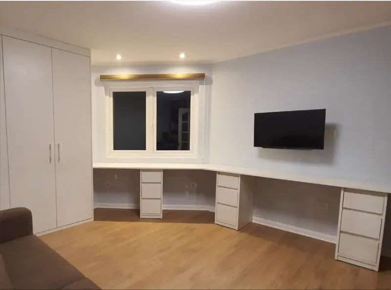 Oficina en casa con mesón continuo en L de tablero Blanco Soft, tres cajoneras bajo cubierta y clóset de dos puertas al costado